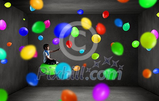 Cute school boy sitting on balloon and using his smartphone Cute school boy sitting on balloon and using his smartphone