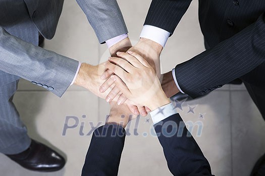 Close up of business peoples hands on top of each other Close up of business peoples hands on top of each other