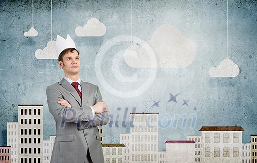 Young handsome businessman wearing white paper crown