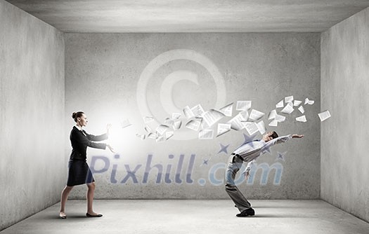 Young businessman trying to evade from thrown paper documents Young businessman trying to evade from thrown paper documents