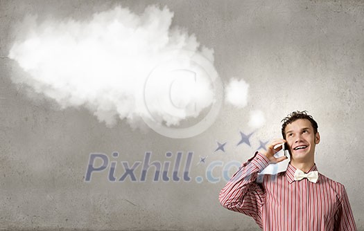 Young funny man in bow tie talking on mobile phone Young funny man in bow tie talking on mobile phone