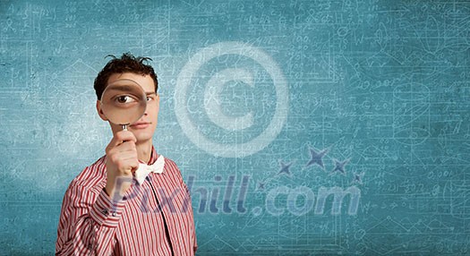 Funny image of young man looking in magnifying glass Funny image of young man looking in magnifying glass