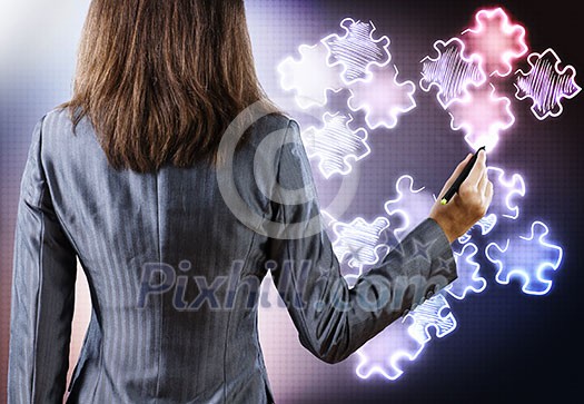 Rear view of businesswoman drawing puzzle elements