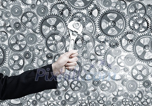 Close up of businessman hand fixing mechanism with spanner Close up of businessman hand fixing mechanism with spanner