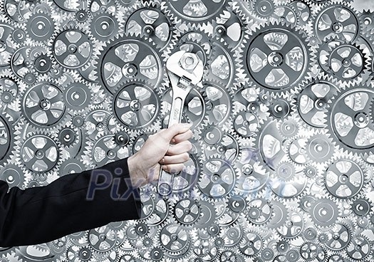 Close up of businessman hand fixing mechanism with spanner