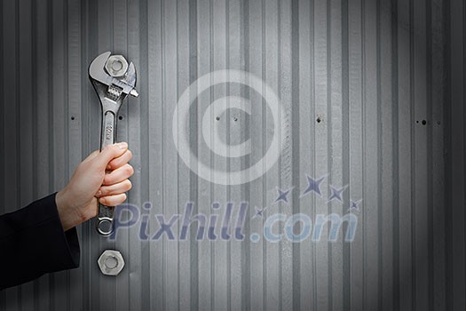 Close up of businessman hand fixing mechanism with spanner Close up of businessman hand fixing mechanism with spanner