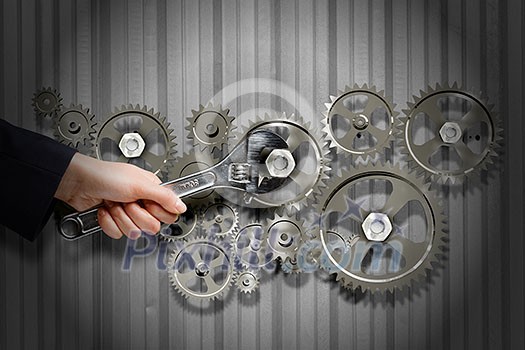 Close up of businessman hand fixing mechanism with spanner Close up of businessman hand fixing mechanism with spanner