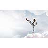 Young determined karate man on cloud high in sky