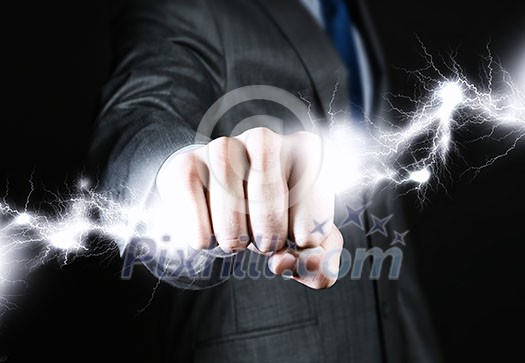 Close up of businessman hand holding lightning in fist Close up of businessman hand holding lightning in fist