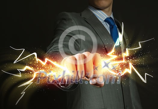 Close up of businessman hand holding lightning in fist Close up of businessman hand holding lightning in fist