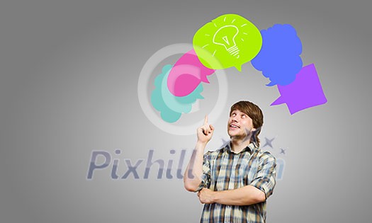 Young thoughtful man and colorful speech bubbles above