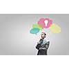 Young thoughtful businessman and colorful speech bubbles above