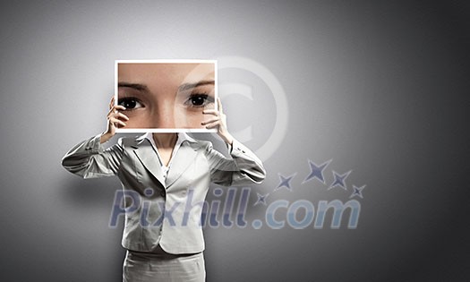 Businesswoman hiding face behind photo of eyes Businesswoman hiding face behind photo of eyes