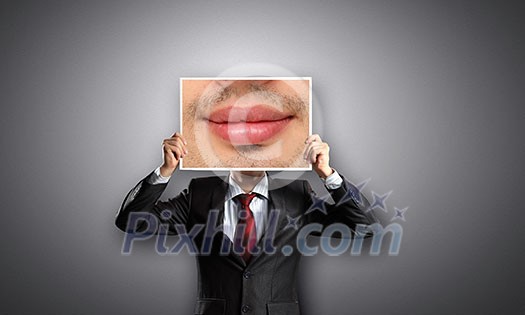 Businessman hiding head behind photo with huge mouth Businessman hiding head behind photo with huge mouth