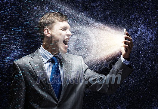 Aggressive businessman screaming fiercely in mobile phone