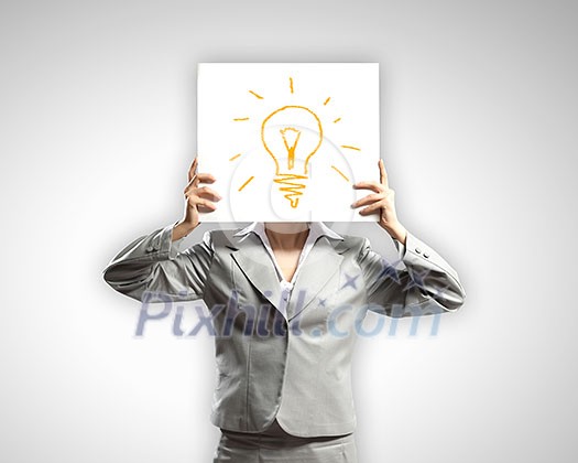 Businesswoman hiding her face with sheet of paper with sketches at background Businesswoman hiding her face with sheet of paper with sketches at background