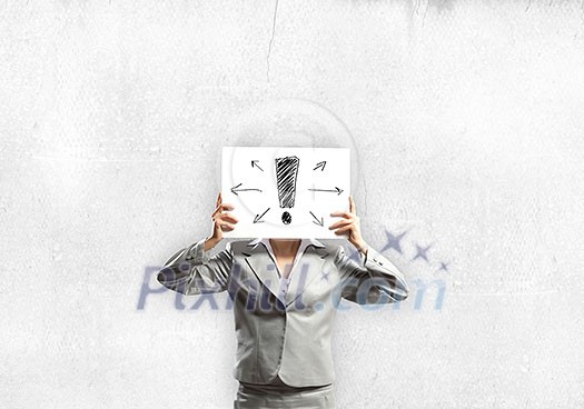 Businesswoman hiding her face with sheet of paper with sketches at background Businesswoman hiding her face with sheet of paper with sketches at background