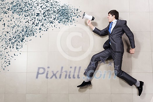 Young businessman running with megaphone in hand Young businessman running with megaphone in hand