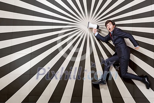 Young businessman running with megaphone in hand