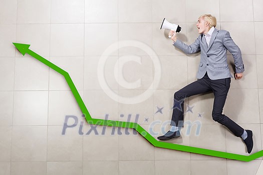 Young businessman running on graph with megaphone in hand Young businessman running on graph with megaphone in hand
