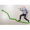 Young businessman running on graph with megaphone in hand