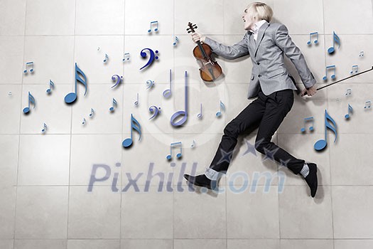 Young businessman running with violin in hand