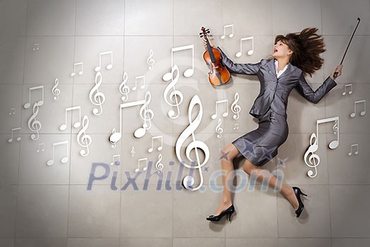 Attractive emotional businesswoman with violin in hands