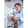 Senior male researcher carrying out scientific research in a lab (shallow DOF; color toned image)