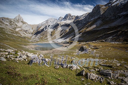 Splendid mountain lake in Swiss Alps, Glattalpsee (shallow DOF, focus on the stones in the foreground - the background is kept nicely blurred for placing text)