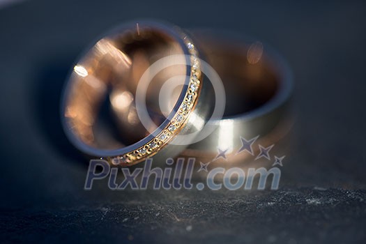 Wedding day details - two lovely golden wedding rings awaiting their moment (shallow DOF; color toned image) Wedding day details - two lovely golden wedding rings awaiting their moment (shallow DOF; color toned image)