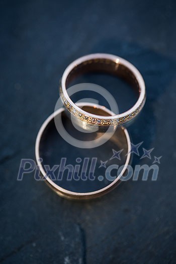 Wedding day details - two lovely golden wedding rings awaiting their moment (shallow DOF; color toned image) Wedding day details - two lovely golden wedding rings awaiting their moment (shallow DOF; color toned image)