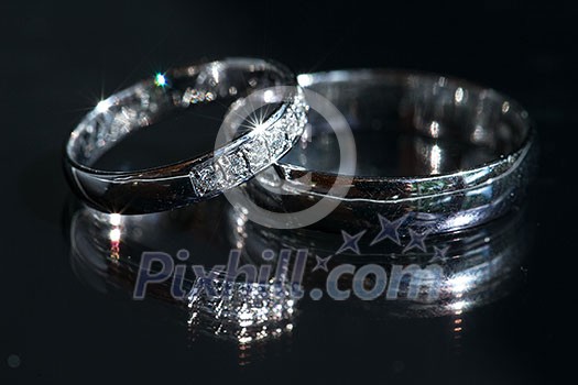 Wedding day details - two lovely golden wedding rings awaiting their moment, with some nice reflections Wedding day details - two lovely golden wedding rings awaiting their moment, with some nice reflections