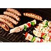 Sausages and chicken kebabs on a barbecue