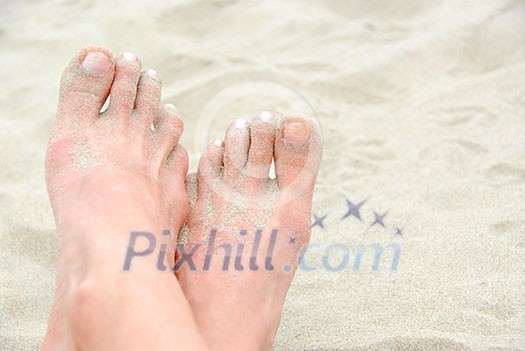 Crossed sandy feet on a beach