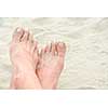 Crossed sandy feet on a beach