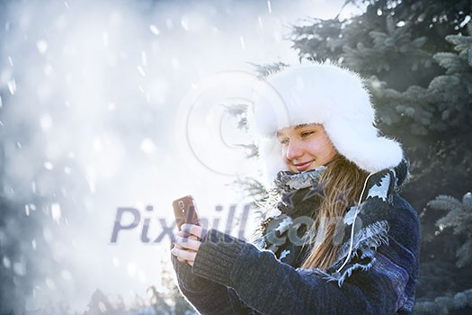 Portrait of teenage girl holding mobile phone outside in winter Portrait of teenage girl holding mobile phone outside in winter