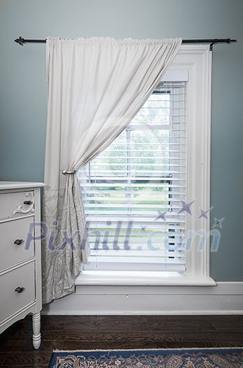 Window with venetian blinds and white curtain in country style room