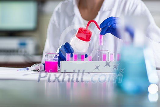 Hands of a female researcher carrying out research in a chemistry lab (color toned image; shallow DOF) Hands of a female researcher carrying out research in a chemistry lab (color toned image; shallow DOF)
