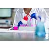 Hands of a female researcher carrying out research in a chemistry lab (color toned image; shallow DOF)