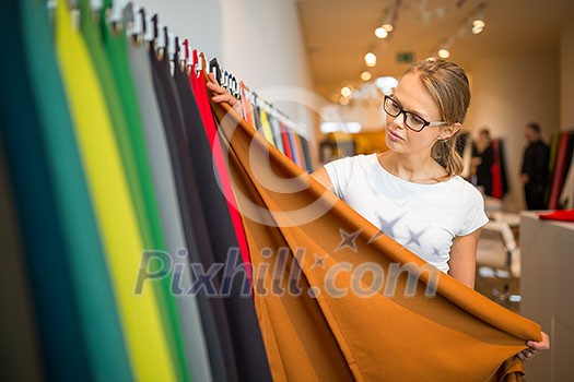 Pretty young woman  choosing the right material/color for her modern appartement interior (shallow DOF; color toned image)