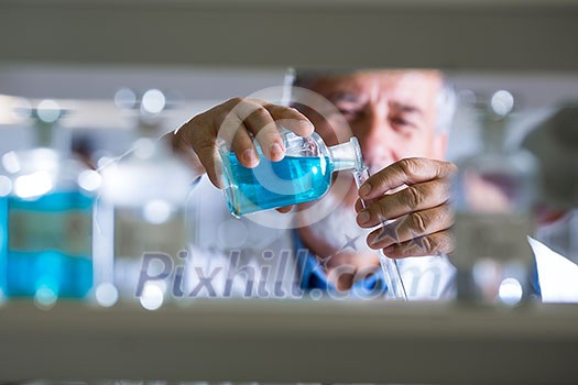 Senior male researcher carrying out scientific research in a lab (shallow DOF; color toned image) Senior male researcher carrying out scientific research in a lab (shallow DOF; color toned image)