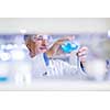 Senior male researcher carrying out scientific research in a lab (shallow DOF; color toned image)