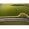 Aerial view of a highway amid fields with cars on it