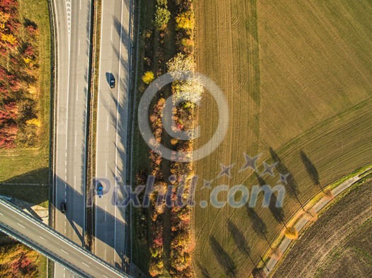 Aerial view of a highway amid fields with cars on it Aerial view of a highway amid fields with cars on it