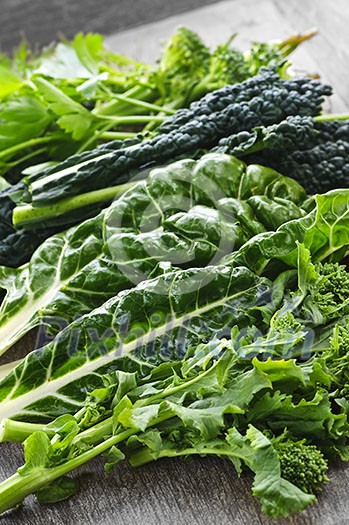 Dark green leafy fresh vegetables on cutting board Dark green leafy fresh vegetables on cutting board