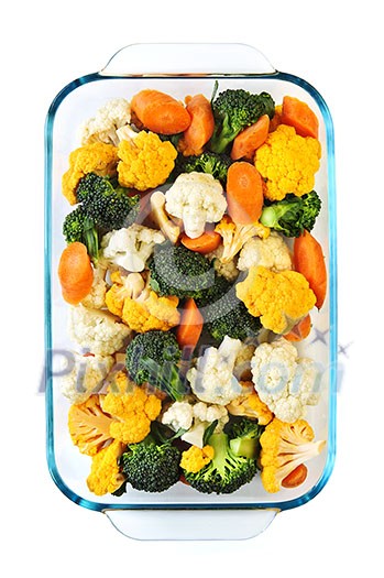 Raw cut vegetables in glass roasting pan Raw cut vegetables in glass roasting pan