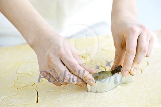 Cutting cookie shapes in rolled dough with cutter