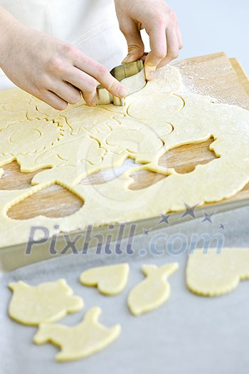 Woman using cookie cutter and baking homemade cookies Woman using cookie cutter and baking homemade cookies