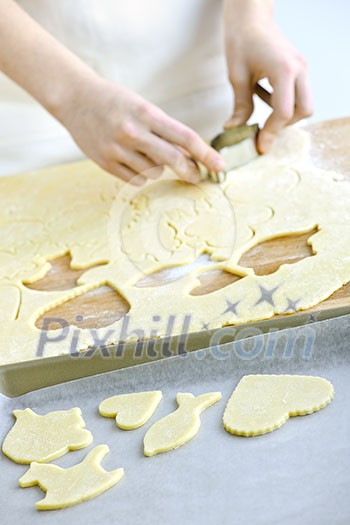 Woman using cookie cutter and baking homemade cookies Woman using cookie cutter and baking homemade cookies