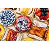 Background of assorted fresh sweet tarts and pastries from above